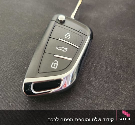 מפתח רכב עם שלושה כפתורים על רקע שחור